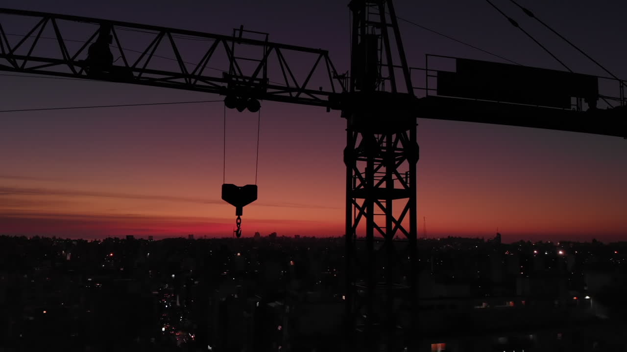 grúa de construcción en la ciudad en la órbita del atardecer disparo de cerca