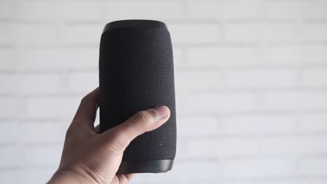 black portable bluetooth speaker in hand