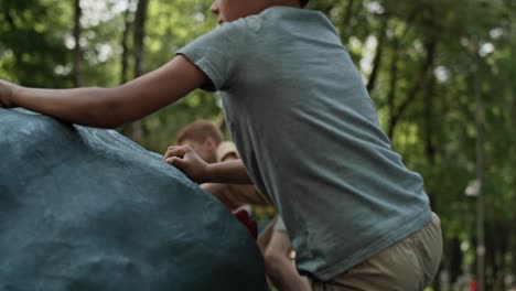 two caucasian elementary boys climbing at playground in sunny day.