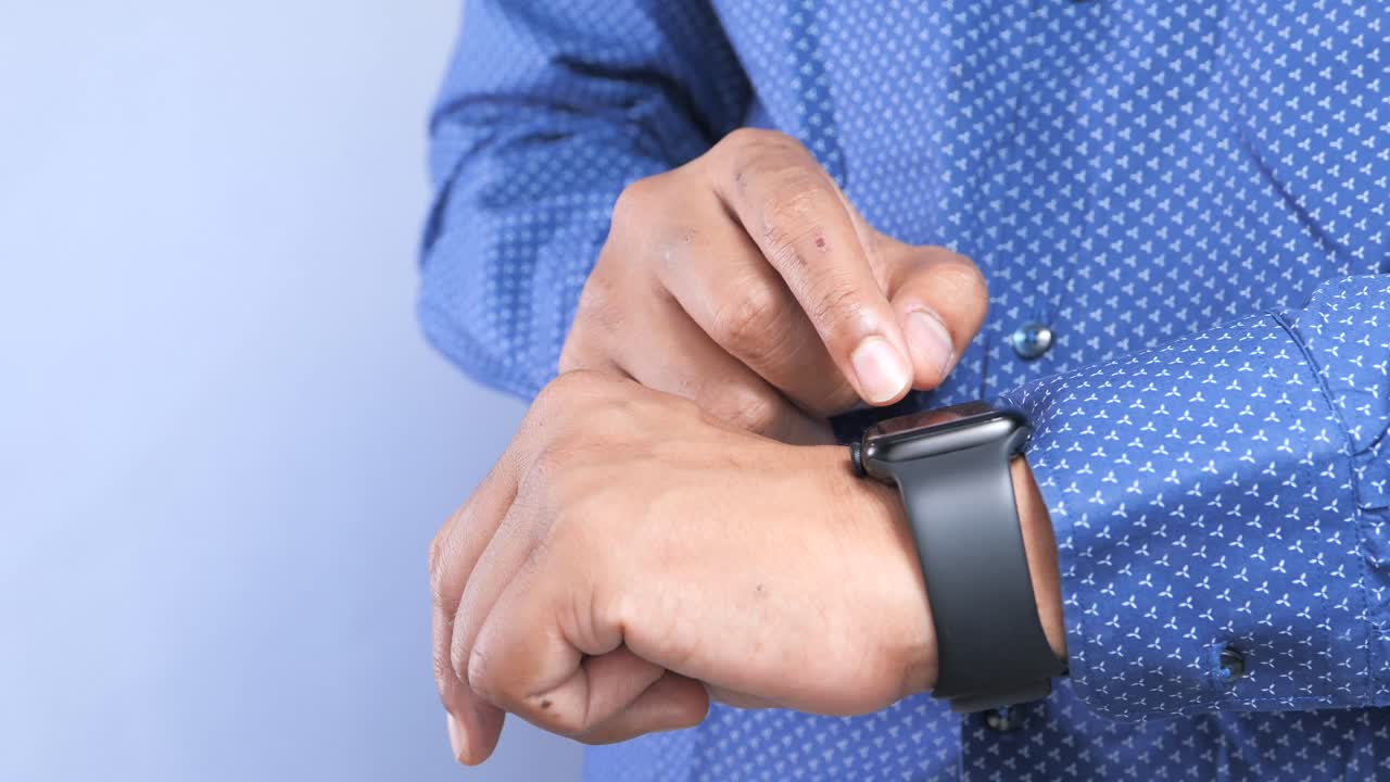 hombre comprobando la hora en el reloj inteligente