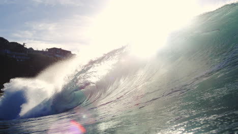 backlit wave crashes in slow motion with glassy sunlit texture