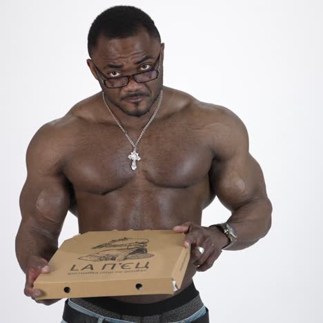 athletic man with fast food. african handsome naked man eats pizza