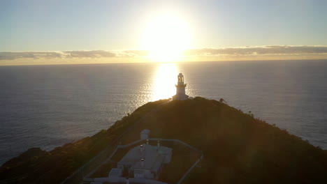 Filmische-Rotation-In-Die-Sonne-Drohnenaufnahme-Des-Rauchigen-Kap-Leuchtturms