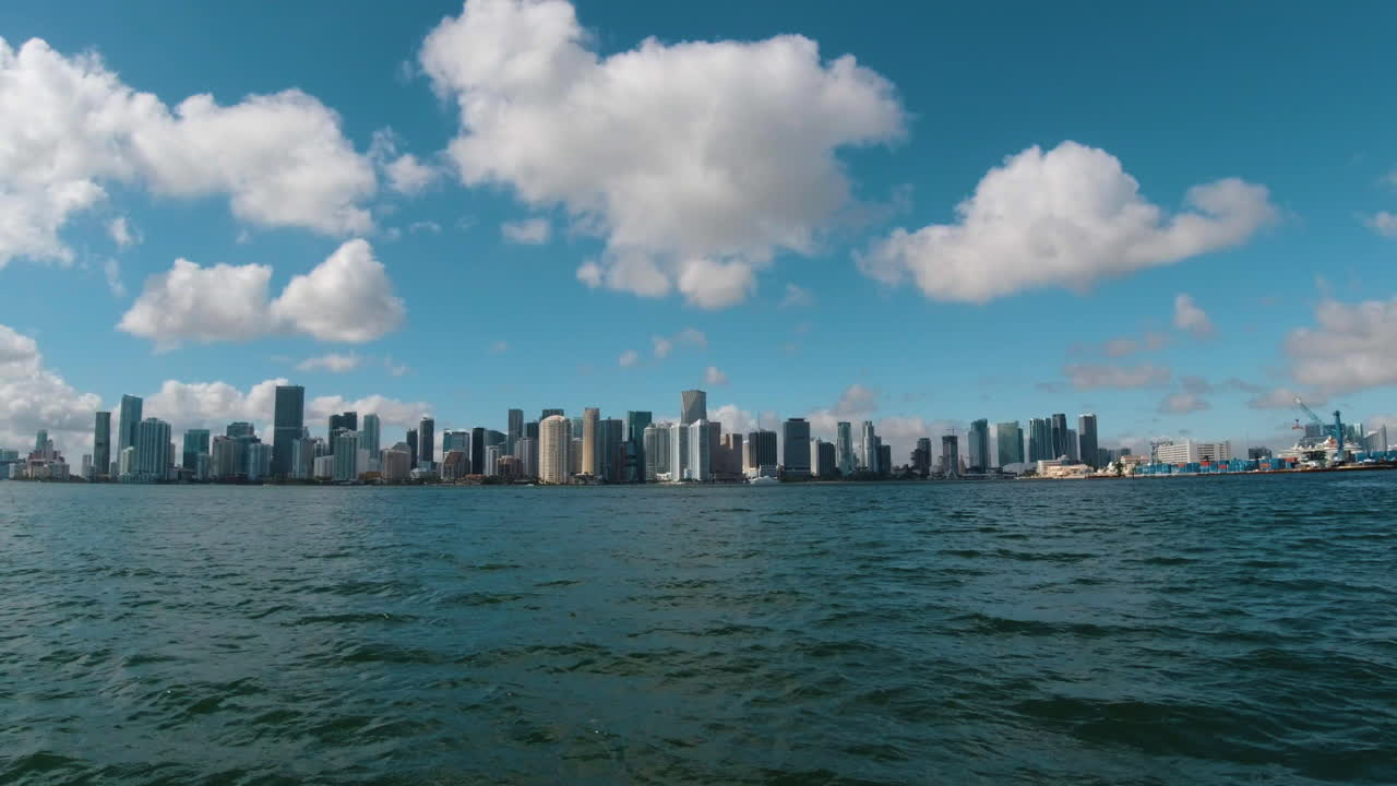 ⁇ 색 구름과 파란 하늘로 마이애미 플로리다에 접근하는 빠르게 움직이는 보트에서의 전망