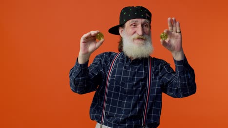 senior man with beard holding two bitcoin coins