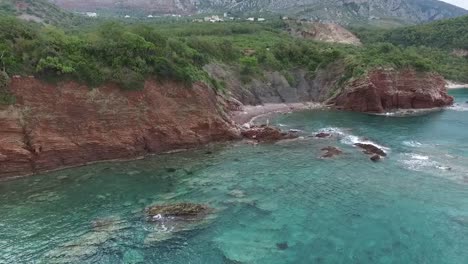bahía costera con acantilados rojos y aguas turquesas