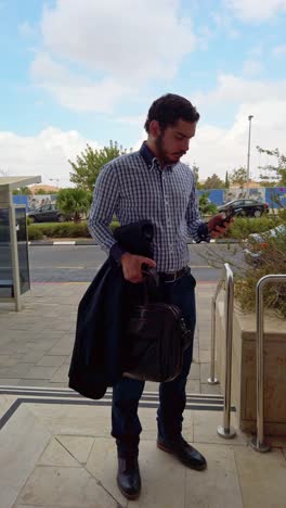 entrepreneur checking phone on building steps