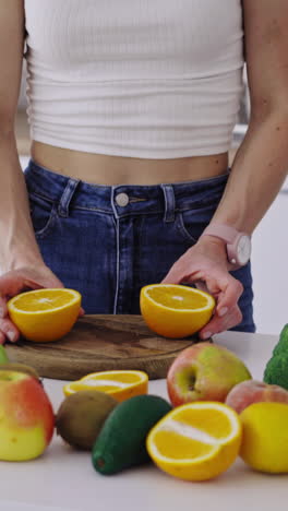 woman cutting fruit in the kitchen. beautiful young woman preparing fruit salad in kitchen vertical video