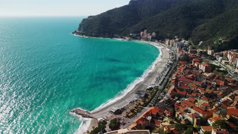 Vista-Aérea-De-La-Costa-De-Playa-Con-Increíbles-Aguas-Turquesas-Del-Mar-En-Liguria,-Italia