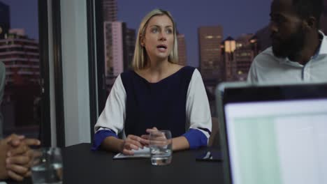 Video-of-caucasian-businesswoman-talking-to-diverse-colleagues-at-evening-office-meeting