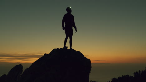 un hombre con una luz de cabeza mientras está fuera de la montaña