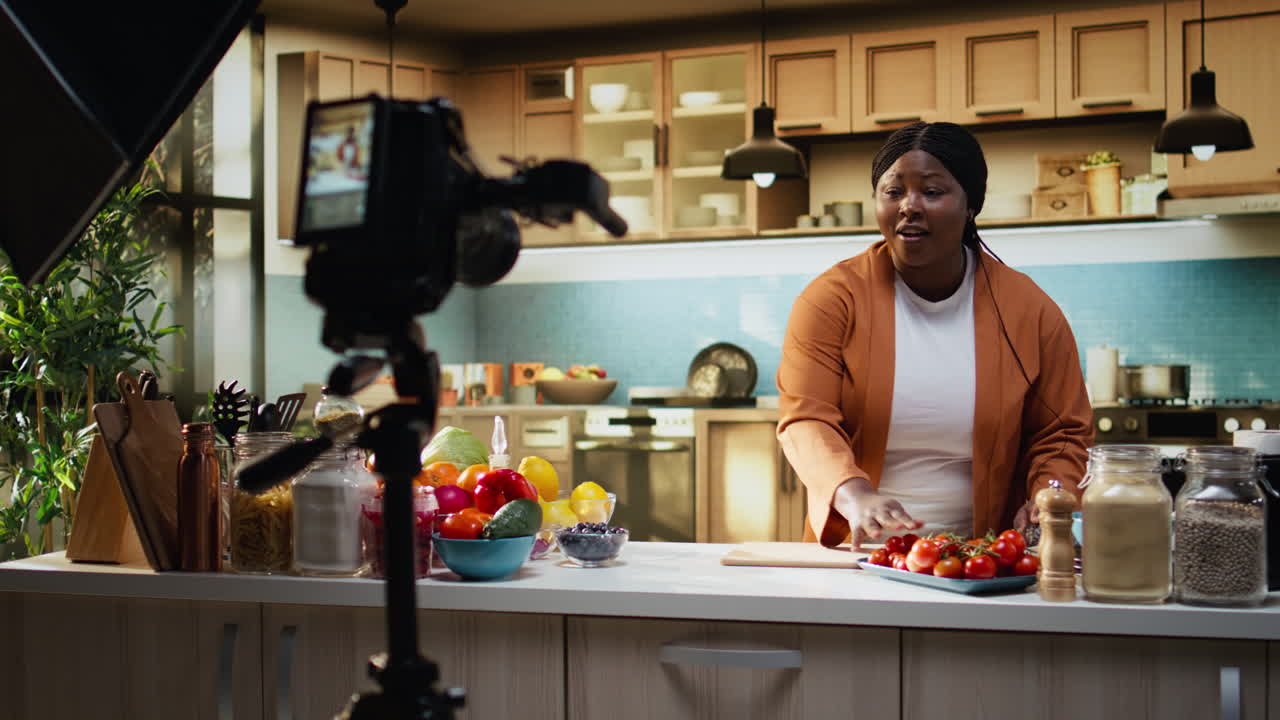 Vlogger di cucina (donna) controlla le impostazioni della fotocamera prima di filmare un video