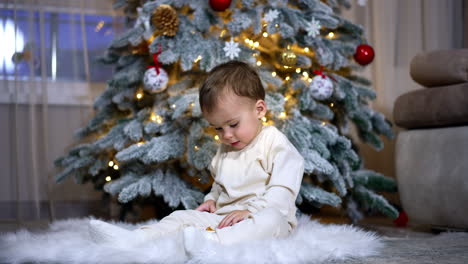 baby playing near christmas tree