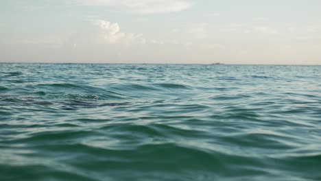 Young-woman-diving-in-serene-ocean-waters,-Philippines,-golden-hour-light