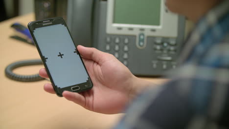man holding his smartphone checking out the screen 4k