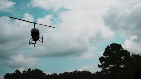 descending helicopter against blue cloudy sky near orlando florida, usa - low angle shot
