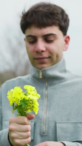 man selecting and picking yellow flowers from the ground