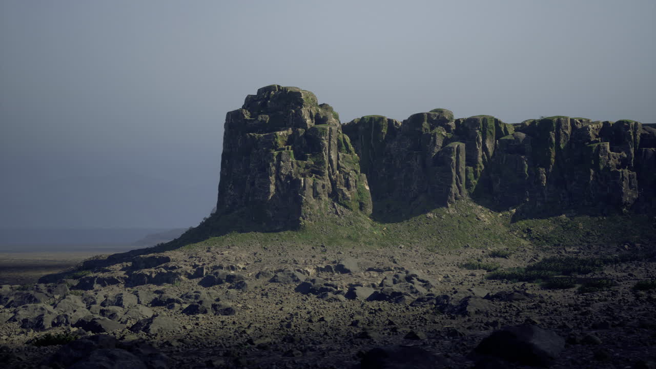 Lush green cliffs rise under moody skies at a serene coastal location