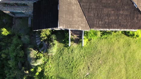 Front-of-dreamy-wood-and-stone-house-in-mountains-at-sunset-tilt-pan-in-Slow-motion