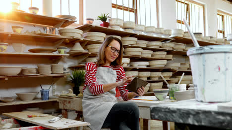 female potter using digital tablet 4k