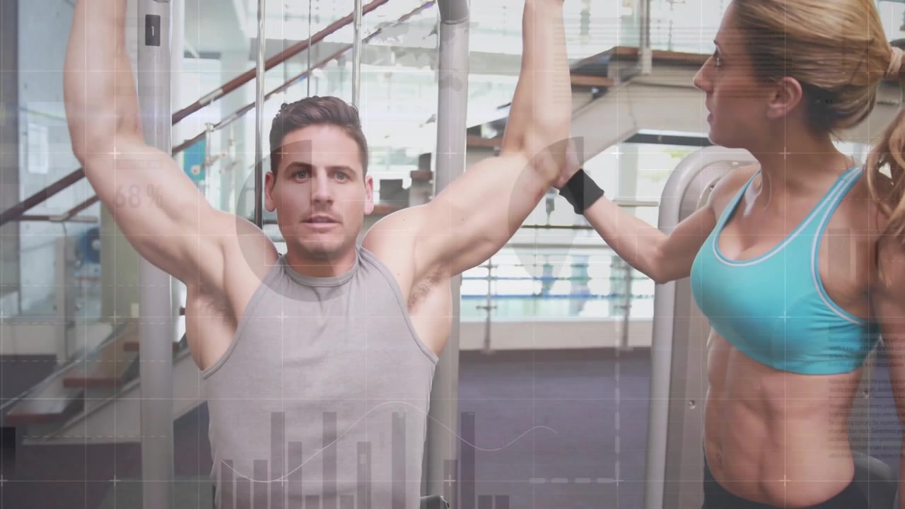 Antrenör rehberliğinde, sırt gücü için baş üstü barı aşağı çekmeden önce nefes alan spor salonu müşterisi.