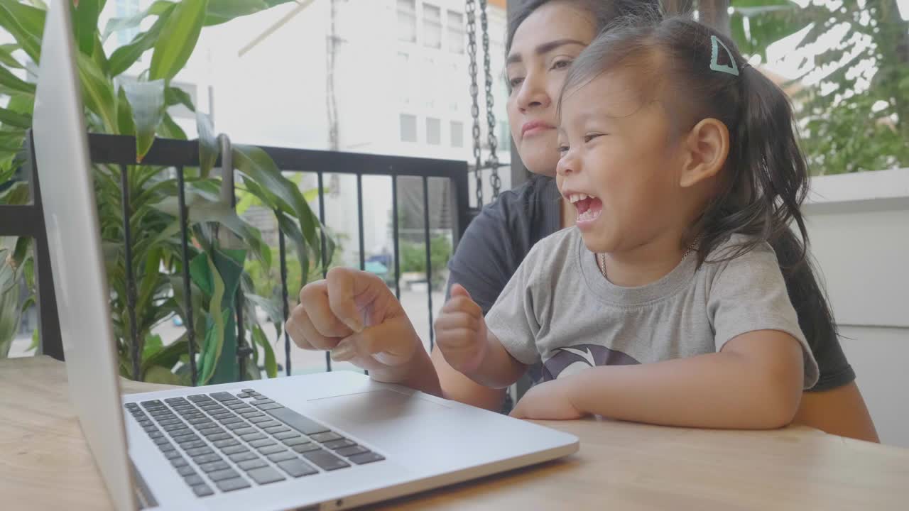 Mother and daughter using computer at home. stock video