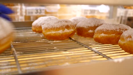 macro hands in blue gloves take donuts away from stack