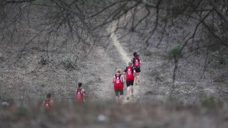 group of marathon athletes running on a dirt road working out difficult race in desert dry nature landscape mountains of ecuador