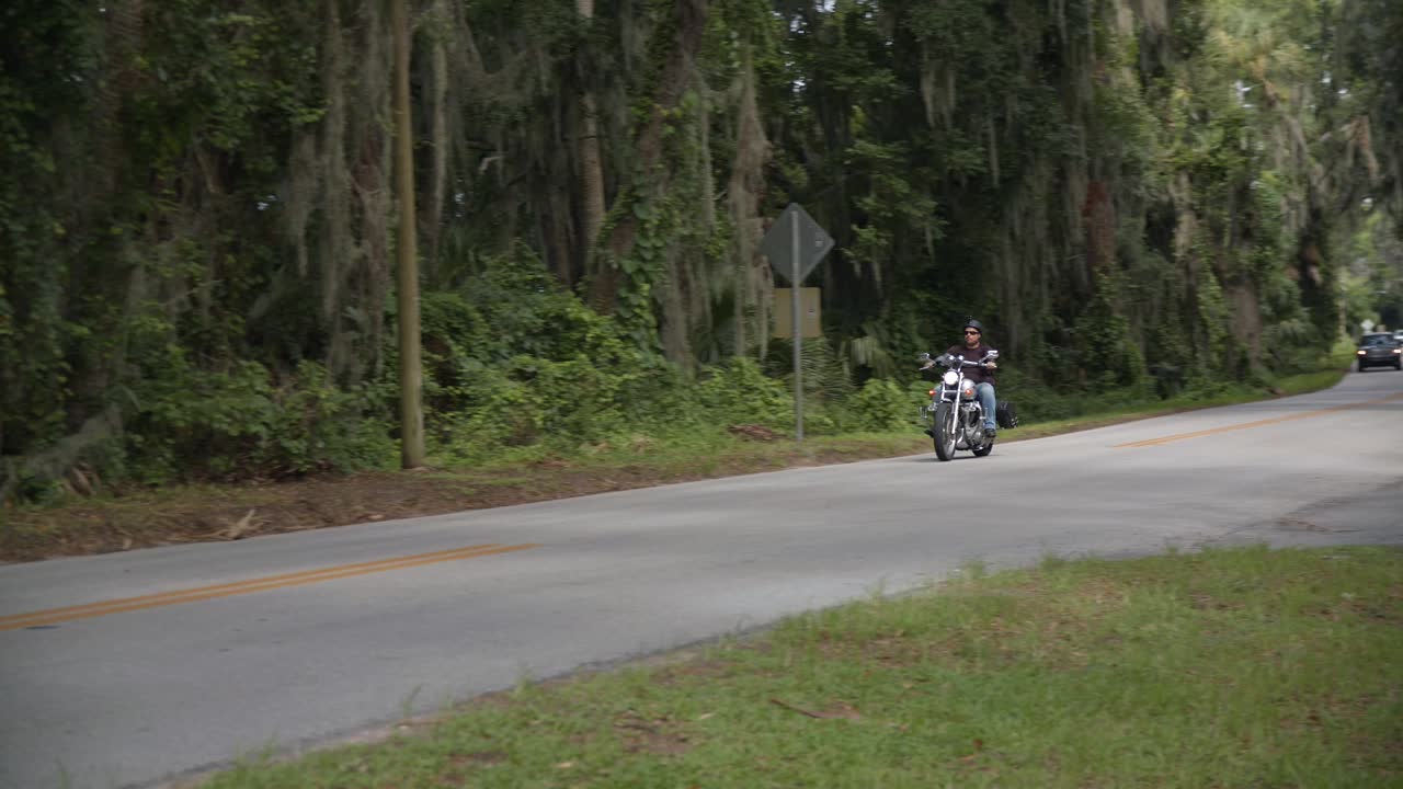 florida, hombre, en, motocicleta, paseos, por, en, un, concurrido, country road