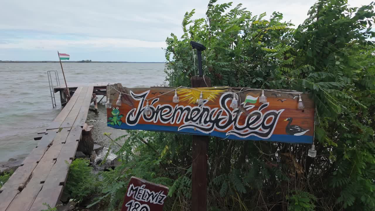 Close-up of the JóreményStég with a waving Hungarian flag on the Lake Tisza in Abádszalók, Hungary