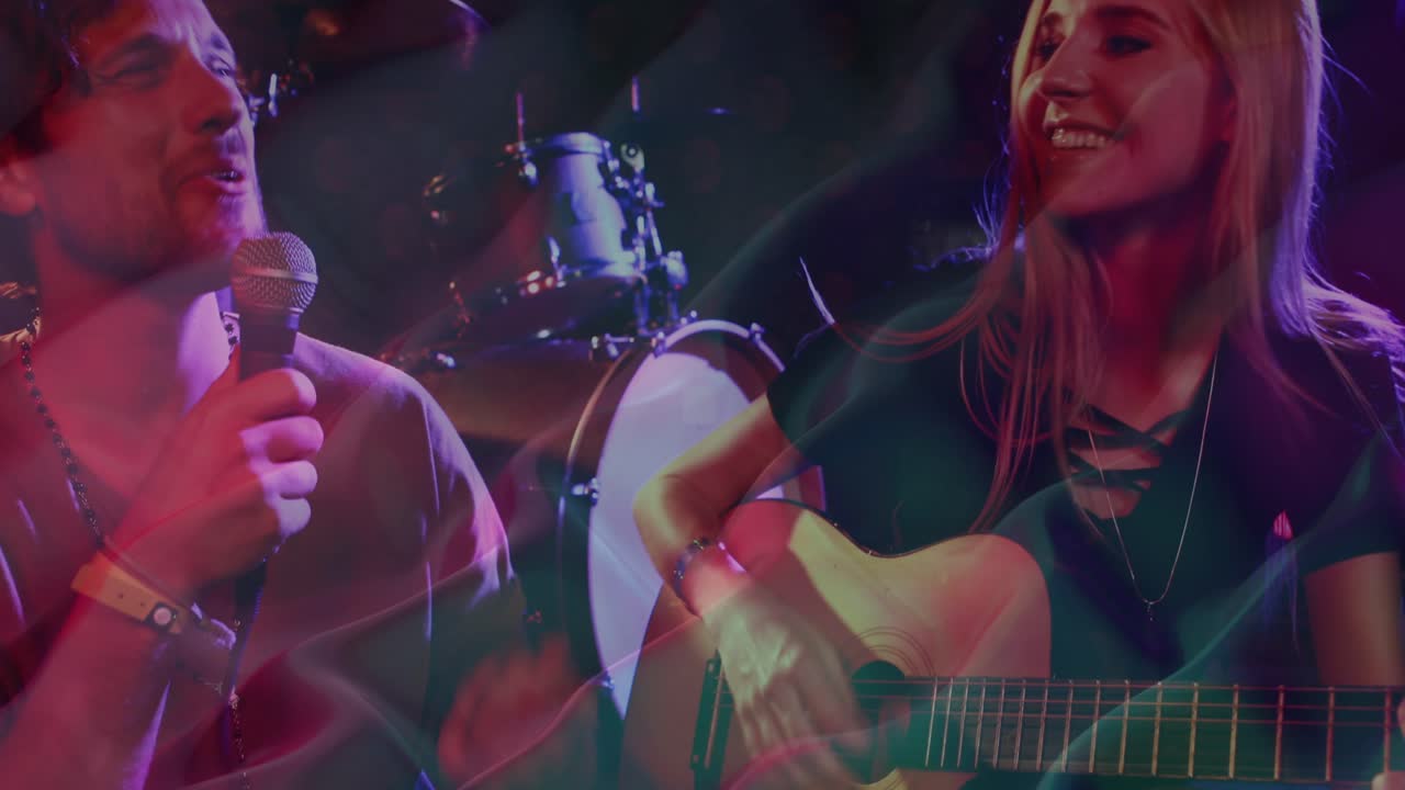 Animação de padrões de ondas em movimento sobre mulher caucasiana tocando guitarra e homem cantando em concerto