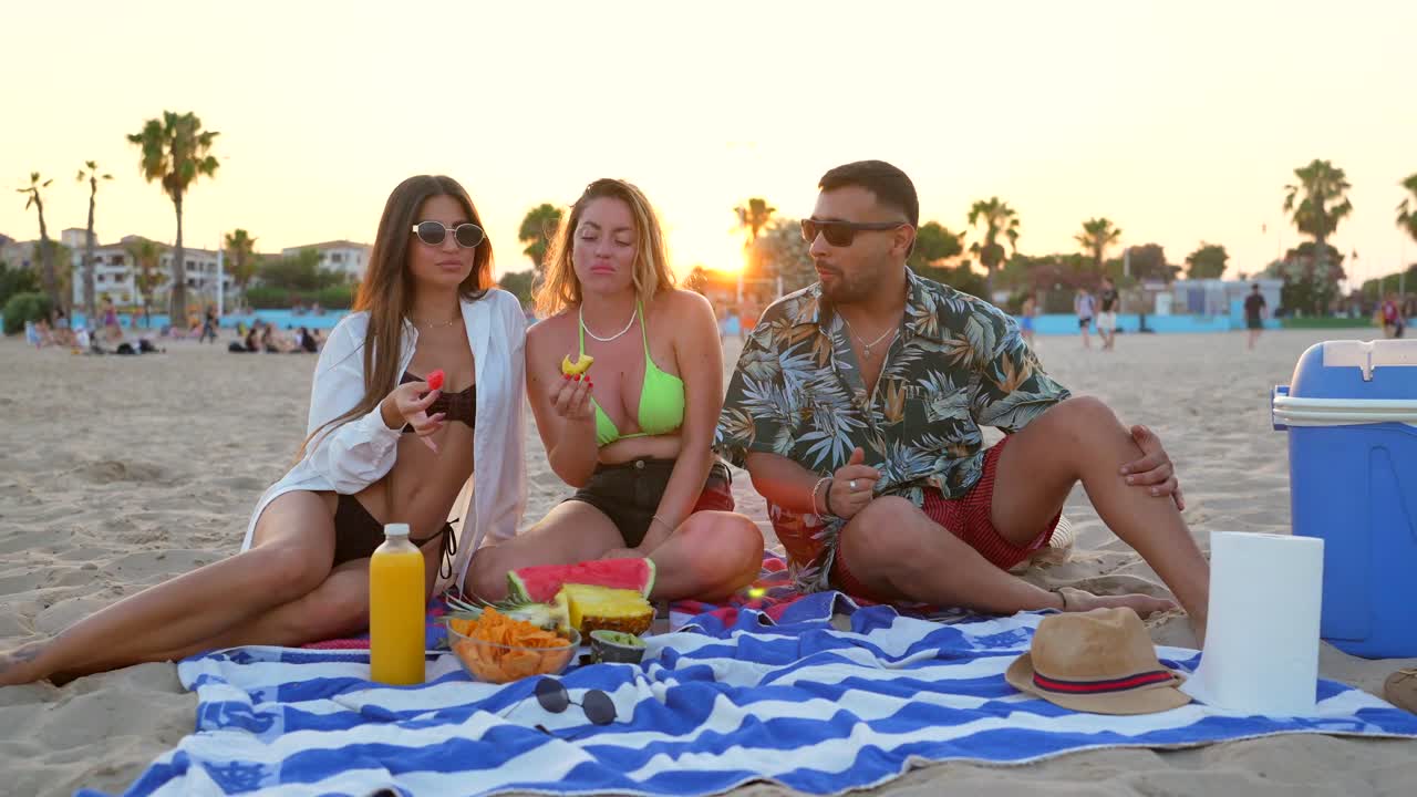 Amici che hanno un picnic in spiaggia