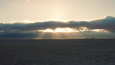 beautiful god ray sunbeams through clouds over vast desert at sunrise