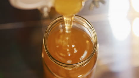 close-up of jar filling with healthy honey