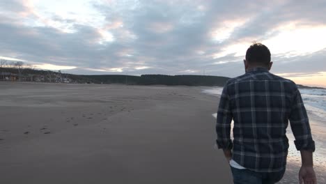 hombre caminando por la playa