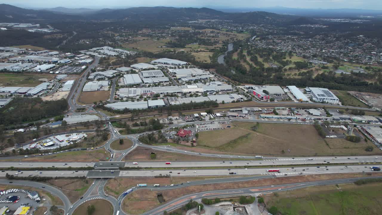 la bulliciosa autopista del pacífico y los edificios industriales en yatala, queensland, australia
