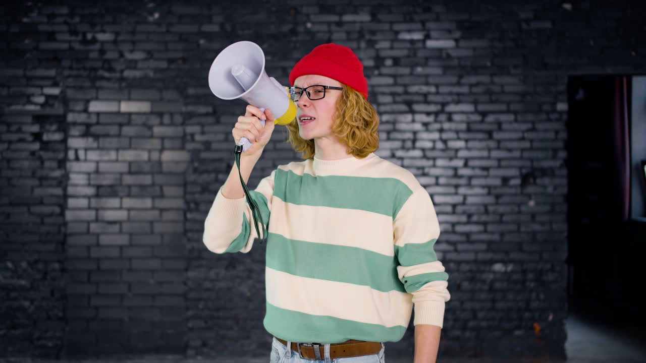 Smiling young Caucasian environmental activist protesting with megaphone indoors