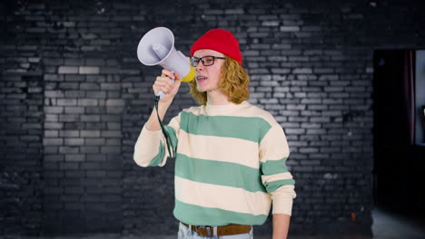 smiling young caucasian environmental activist protesting with megaphone indoors