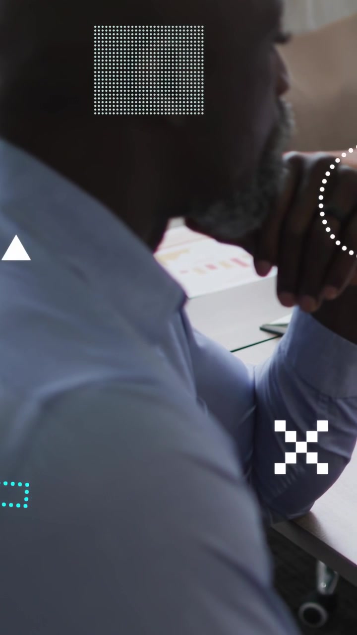 Vertical video: Male leaning at desk, arm causing HUD overlays obscuring face analyzing finance