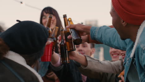 group of friends drinking alcohol making toast having fun on rooftop party gathering enjoying hanging out together chatting sharing pizza at sunset