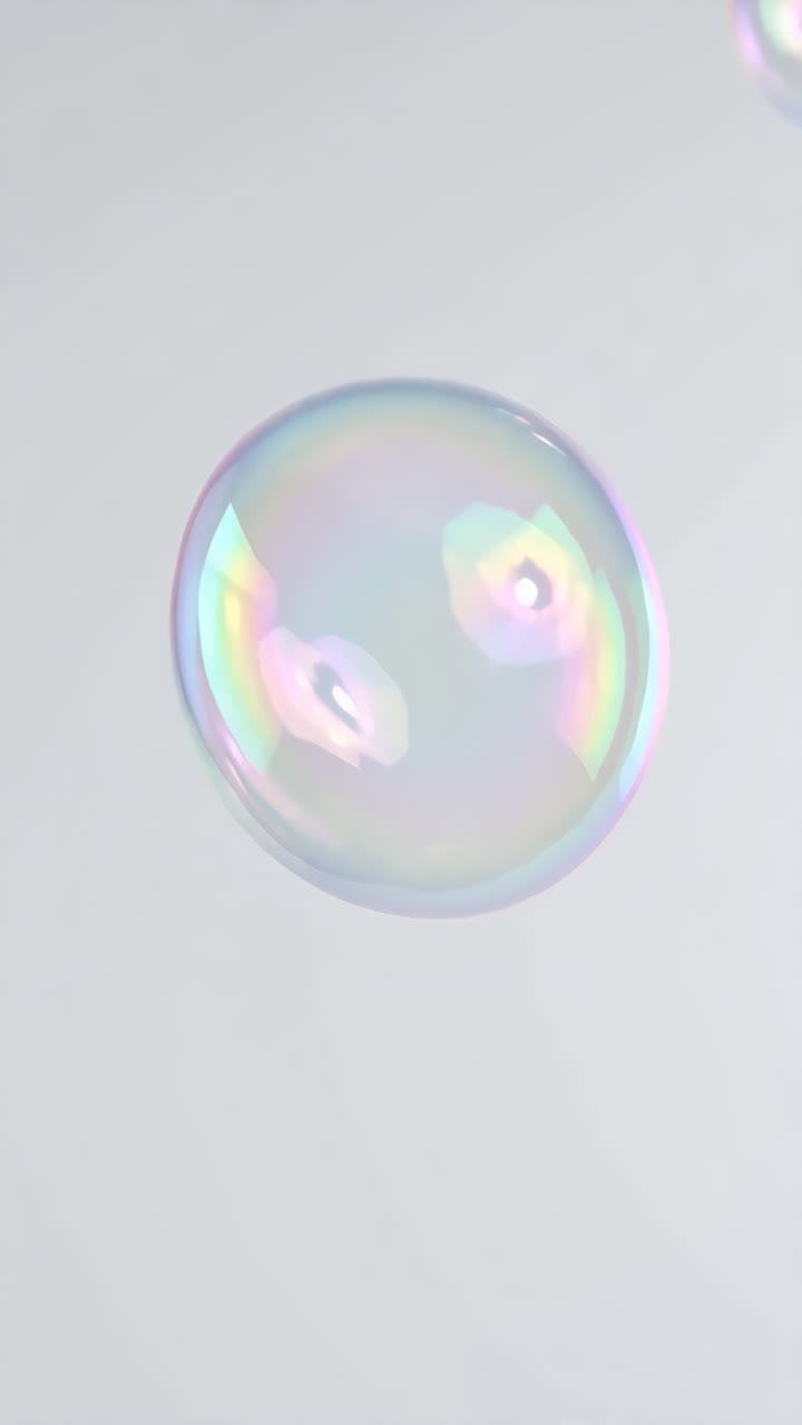 Bolle di sapone iridescenti fluttuanti su grappoli grigi che salgono al rallentatore con sottili riflessi arcobaleno
