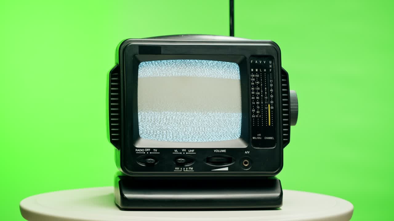 크로마 녹색 배경에 회색 간섭 스크린을 가진 작은 오래된 텔레비전. 빈티지 tv의 클로즈업, 향수, 회색 노이즈 스크린 및 고장