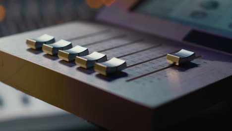 geluidsingenieur die werkt op gemotoriseerde faders controller in een professionele studio