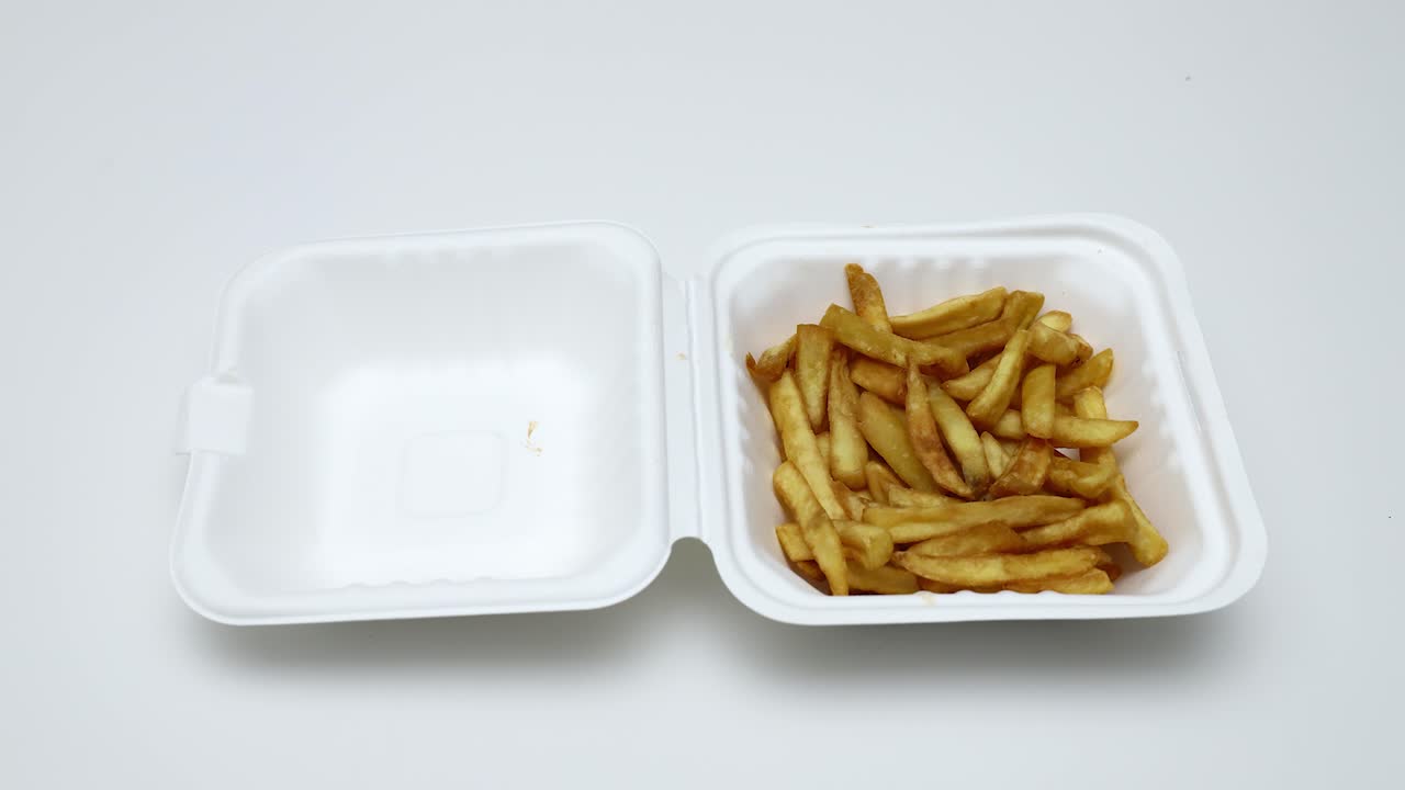 hermoso primer plano de una caja de papas fritas que desaparecen del paquete uno por uno