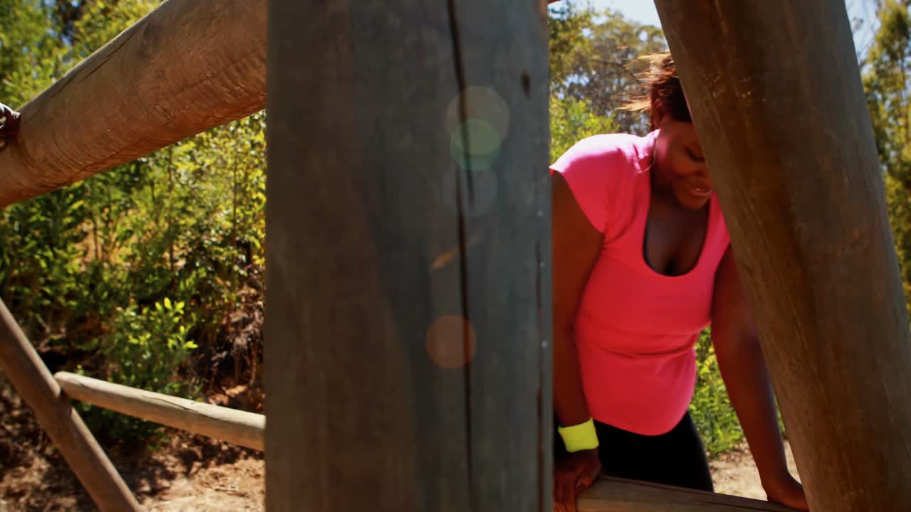 mujer haciendo ejercicio en equipos al aire libre durante una carrera de obstáculos