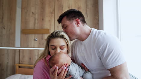 beautiful caucasian couple with a newborn child. loving and caring parents in the hospital after childbirth.