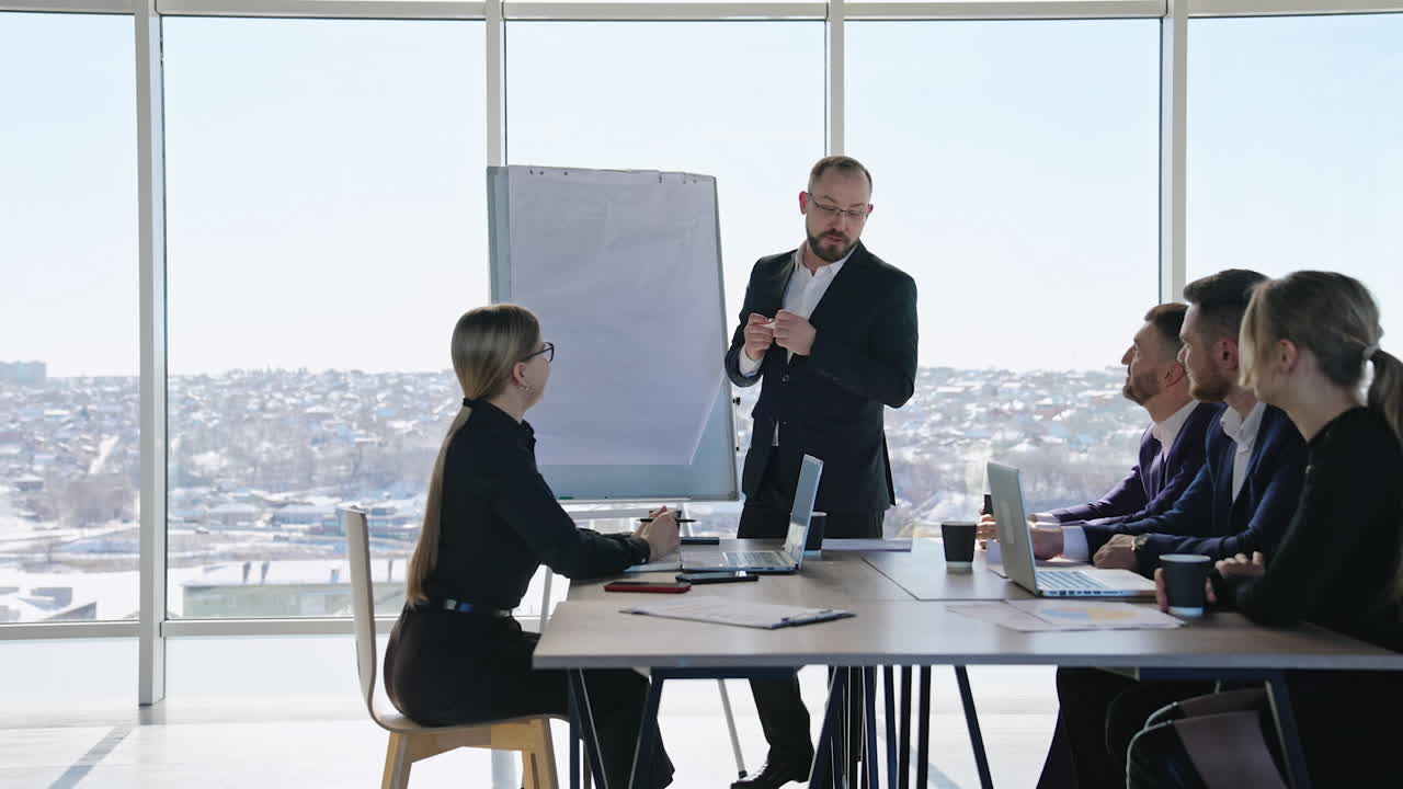 Businesspeople having discussion in the meeting at office. Middle-aged male manager performs presentation for colleagues.