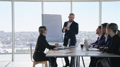 businesspeople having discussion in the meeting at office. middle-aged male manager performs presentation for colleagues.