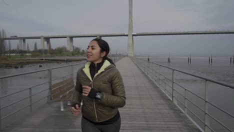 Smiling-hindu-woman-running-on-wooden-pier-on-seaside