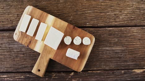 Slices-of-cheese-on-wooden-board